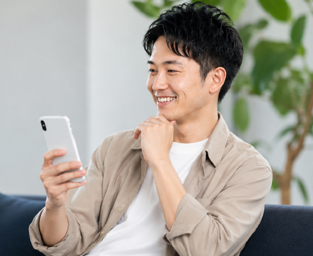 スマホを見て考えている男性