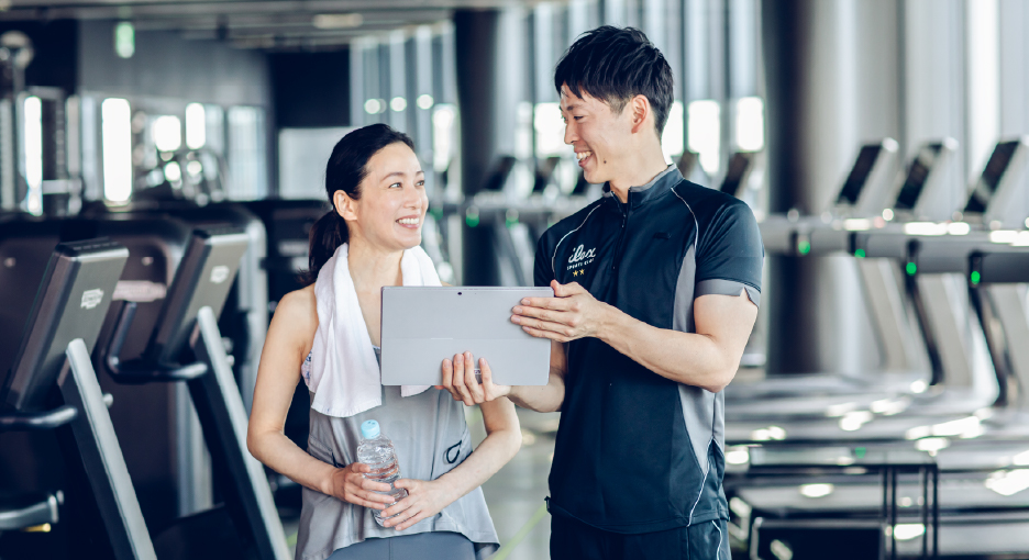 トレーナーが女性をサポートしている写真